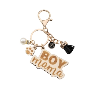 Wooden BOY MAMA keychain with black tassel, pearl, and paw print charm on white background