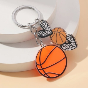 Acrylic leopard print heart keychain with orange basketball charms on a white pedestal