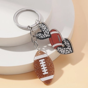 Creative keychain featuring glittery footballs and leopard print hearts on silver rings