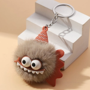 Creative plush monster keychain with brown fur and orange cap on white steps
