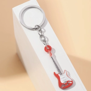 Macro view of double-sided red acrylic guitar keychain with Mark engraving and silver ring