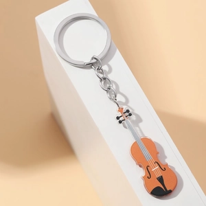 Macro view of a violin-shaped acrylic keychain featuring detailed orange finish and metal ring