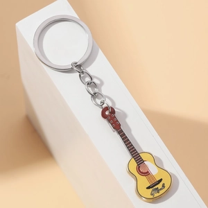 Detailed close-up of a bright yellow acrylic guitar keychain with metallic silver chain