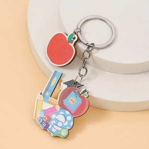 Creative wooden apple keychain with school elements and ABC blocks on a white display stand