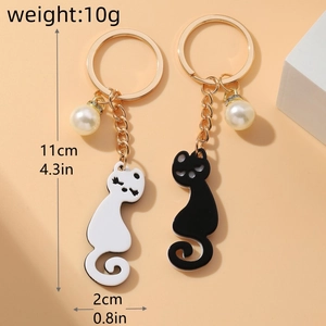 Detail view of cute black and white acrylic cat keychains with pearls and dimensions