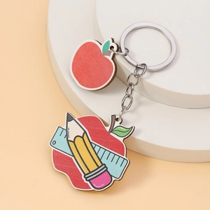 Macro detail of wood apple keychain with pencil and ruler school theme design