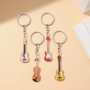 Set of four acrylic musical instrument keychains including guitars and violin on white stairs