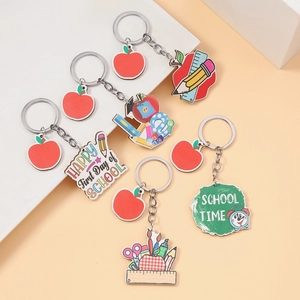 Macro detail of apple and pencil pendants from the School Time five-piece keychain set