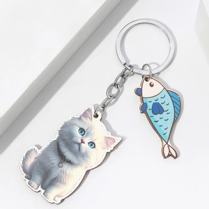 Detailed macro view of 3D acrylic cat and fish charms with a silver keyring