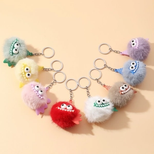 Detailed close-up showing eight colorful furry monster keychains with funny expressions