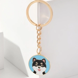 Close-up of golden alloy keychain featuring a cute enamel Shiba Inu dog charm design