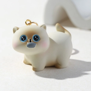 Close-up of 3D resin kitten charm with blue eyes and detailed metal keyring loop