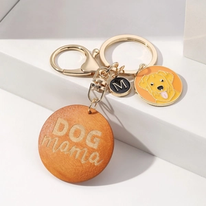 Detail of DOG MAMA wooden charm, golden retriever tag and letter M on keychain