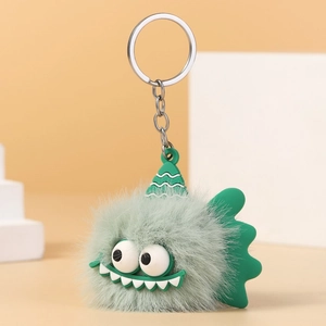 Detailed view of a light green plush monster keychain with big eyes and a silver ring