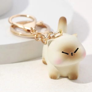 3D cartoon siamese cat resin keychain with gold ring on minimalist white display stand