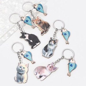 Detail of 5 realistic 3D cat keychains with blue striped fish pendants on white background