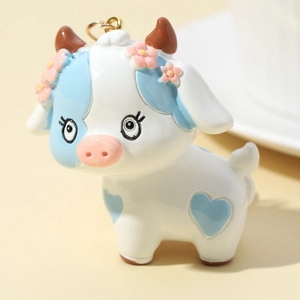 Cute 3D cartoon cow keychain with blue patches and floral head decoration for bags