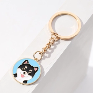 Detailed view of enamel shiba inu dog keychain with gold finish and light blue charm