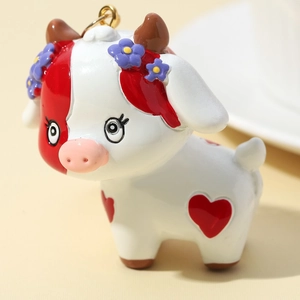 3D cute cartoon cow keychain with red and white patterns and golden metal ring