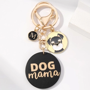 Detail of a DOG mama keychain with schnauzer charm and gold metal hook on beige base