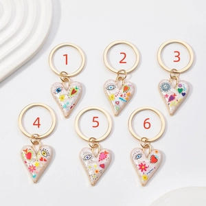 Détails de six porte-clés cœurs en émail avec motifs pop art et anneaux dorés
