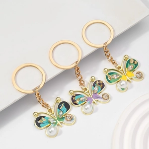 Detailed close-up of colorful enamel butterfly keychains with rhinestones and pearls