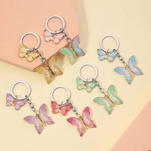 Detail view of six colorful gradient resin butterfly keychains with golden alloy frames