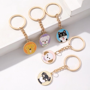 Detail view of five cute alloy puppy keychains with golden metal rings and colorful charms