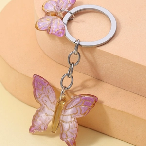 Gradient purple and pink resin butterfly keychain with golden wing textures on metal link