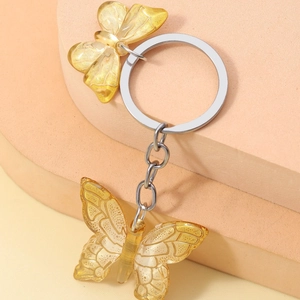 Exquisite yellow resin butterfly keychain with silver metal ring on geometric props
