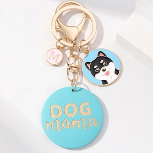 Dog mama keychain with husky charm, blue disc, and golden letter M on white background