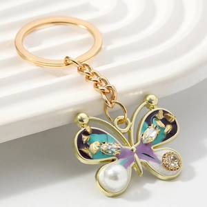 Enamel butterfly keychain with purple wings, sparkling rhinestones and a white faux pearl