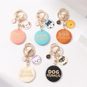 Close-up of five colorful DOG mama leather keychains with dog breed charms and gold hardware
