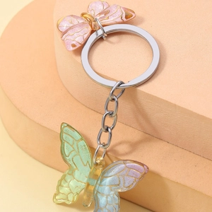 Gradient pink and blue resin butterfly keychain with golden edges on a silver ring