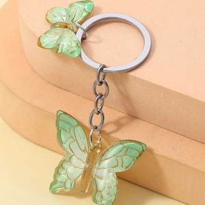 Macro shot of gradient light green resin butterfly pendants with silver keychain links