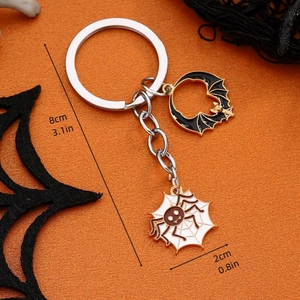 Detailed size view of Halloween bat and spider keychain charm on orange background