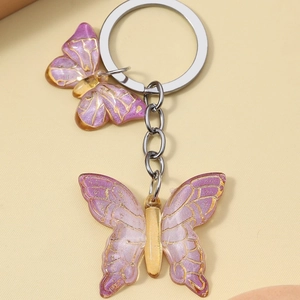 Handmade purple resin butterfly keychain with gold edges and silver metal ring accessory