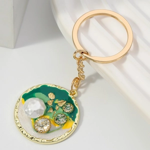 Portachiavi con ciondolo rotondo dorato con smalto verde, perle finte e strass lucidi