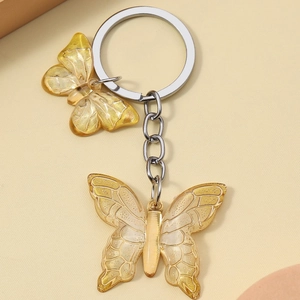 Creative resin butterfly keychain featuring dual gradient wings in light champagne gold