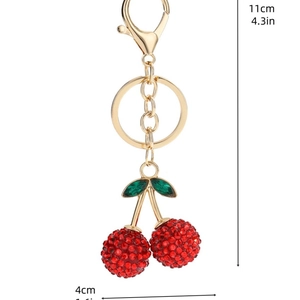 Detail view of crystal-encrusted cherry keychain with gold-tone hardware, size 11cm by 4cm