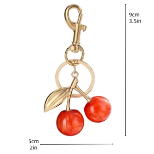 Detail shot of a red cherry keychain with dimensions showing 9cm height and 5cm width