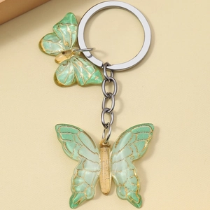 Detailed view of green resin butterfly charms with gold veins on silver metal keychain