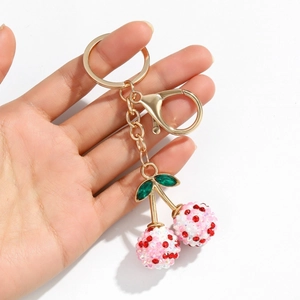 Detail of cherry-shaped rhinestone keychain with sparkling pink crystals and gold-tone lobster clasp