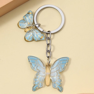 Detail of blue resin butterfly keychains with gold outlines and silver metal ring charms