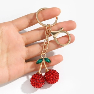 Sparkling cherry keychain with red rhinestones and green leaves on a gold lobster clasp
