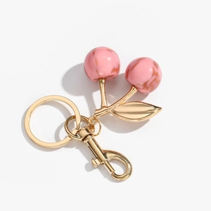Detail of pink marble resin cherry keychain with gold metal leaf and lobster clasp hook