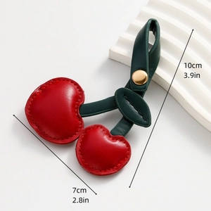 Detail view of 3D leather cherry keychain with dimensions 10x7cm and gold snap button