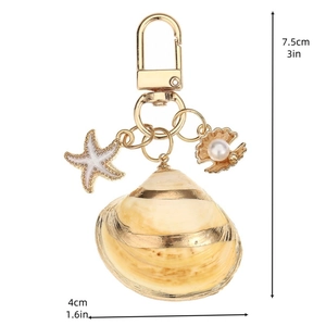 Natural asymmetric seashell keychain with starfish and pearl charm on white background