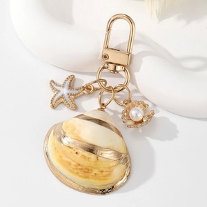 Detailed view of sea shell keychain with starfish, pearl scallop, and golden lobster clasp
