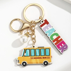 Detail of Best Teacher wooden keychain with yellow school bus, colorful text, and white pearl